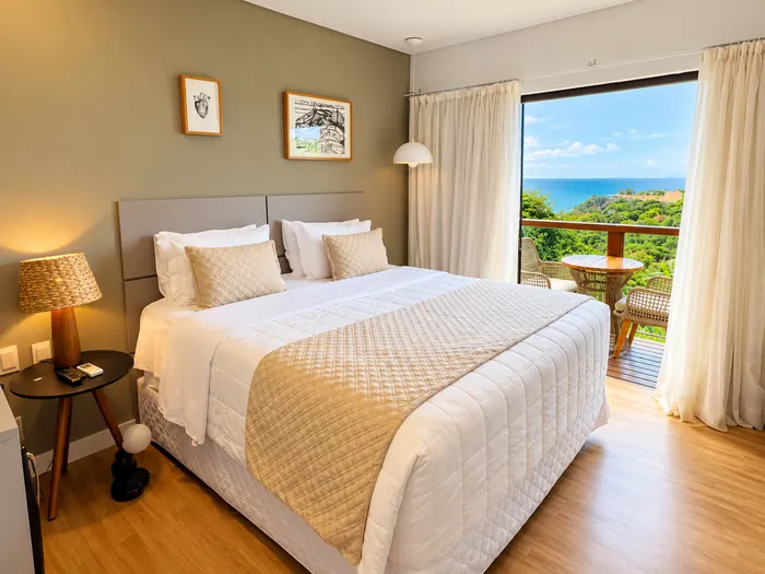 Quarto duplo da Pousada Miragem com cama e varanda vista mar